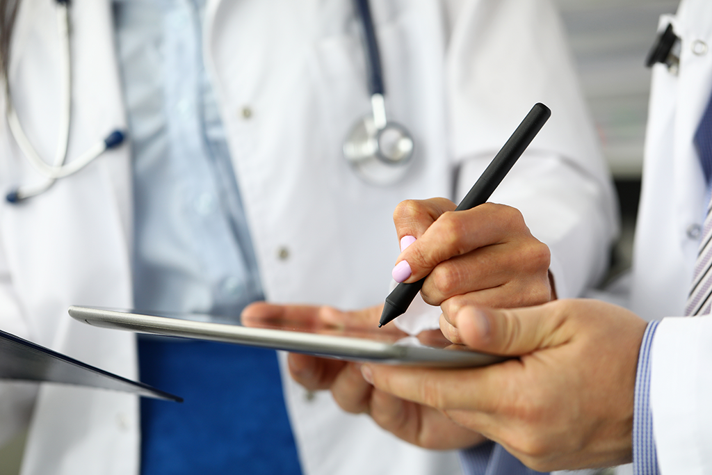 female doctor writing on tablet