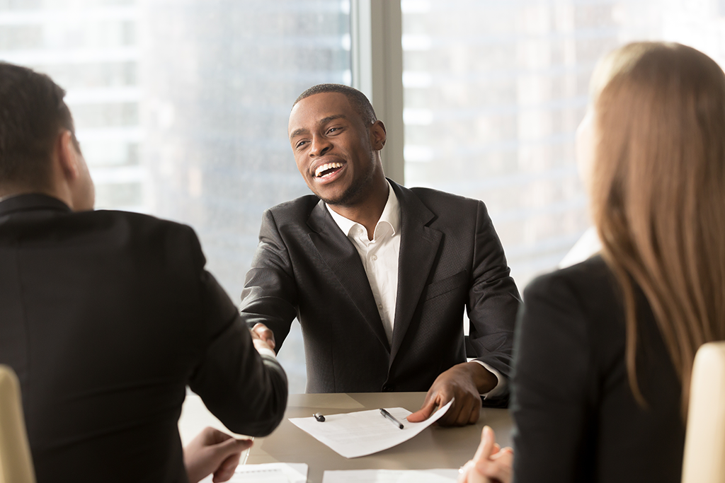 office meeting man shaking other man's hand