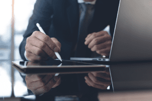 Man writing at desk with reflection